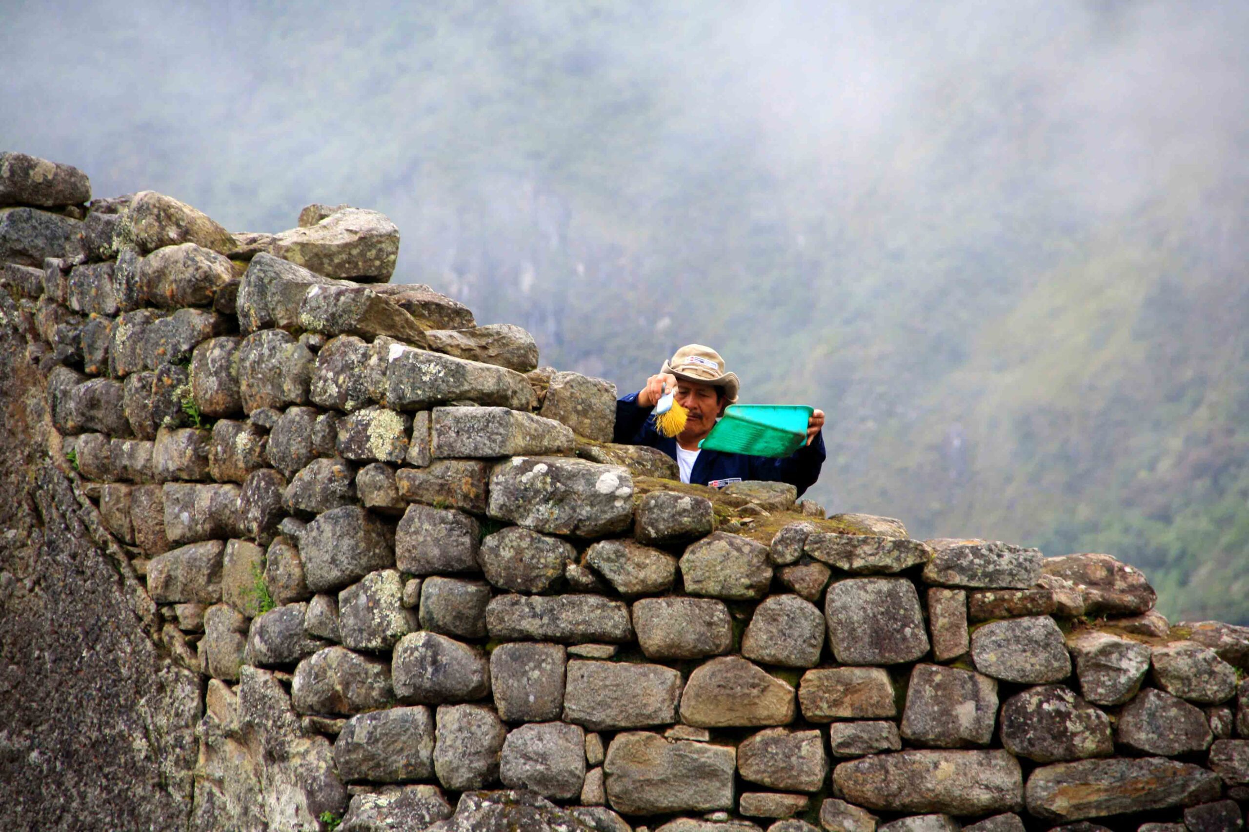 cleaner of the inca walls at machu picchu