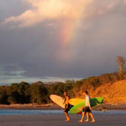 Surfers under the rainbow at Playa Popoyo Nicaragua