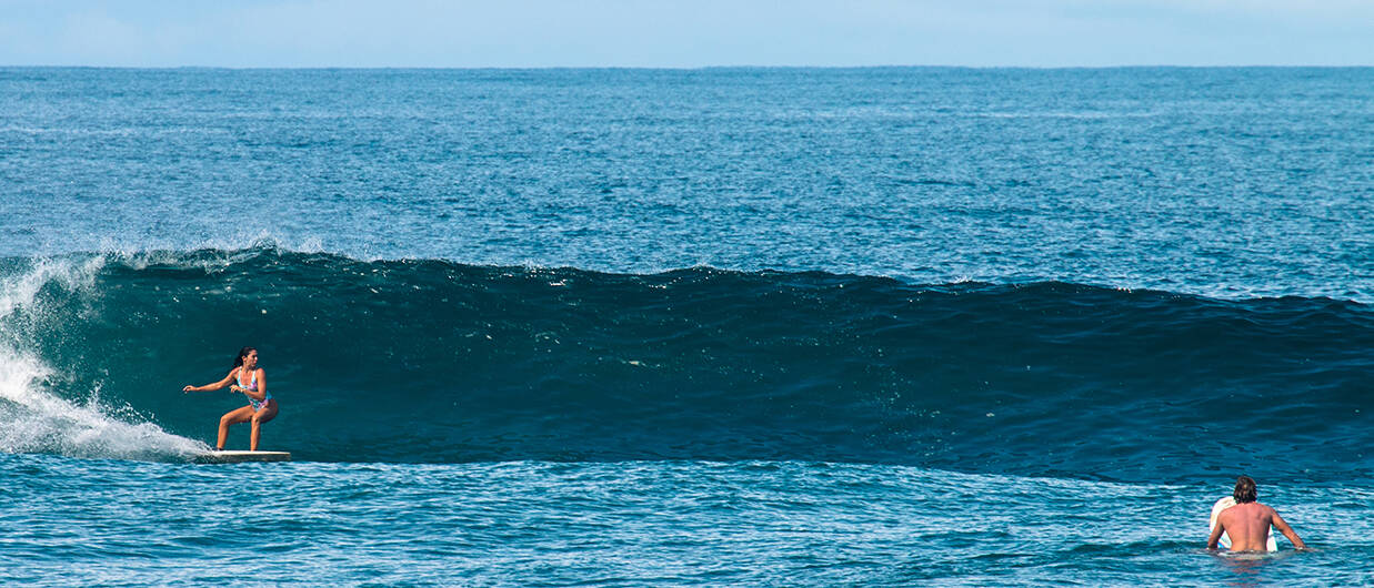 Surfer girl surfing Punta Banco wave in Costa Rica