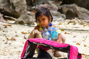 Girl on the beach with plastic bottles in Sumatra