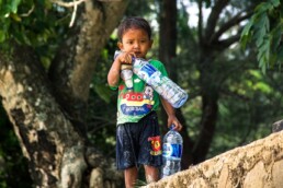 Boy on the beach with plastic bottles in Sumatra