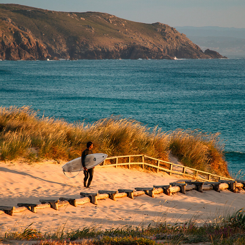 Surfer at sunset at Praia de Doniños