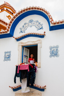 Boy hanging out laundry in old town Ericeira