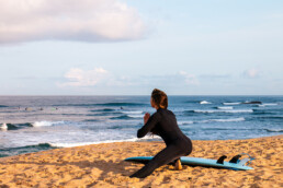surf girl stretching at Ribeira D'Ilhas in Ericeira