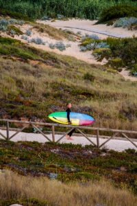 Surfer with surfboard at Praia Foz do Lizandro in Ericeira