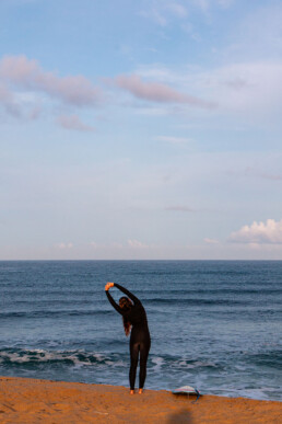 Surf girl stretching at Ribeira D'Ilhas in Ericeira