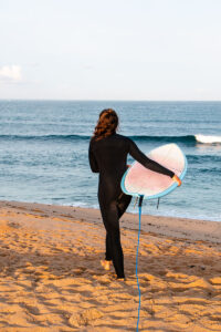 Surf girl at Foz do Lisandro beach in Ericeira Portugal