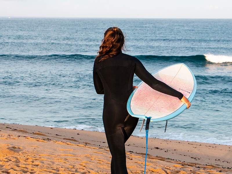 Surf girl at Foz do Lisandro beach in Ericeira Portugal