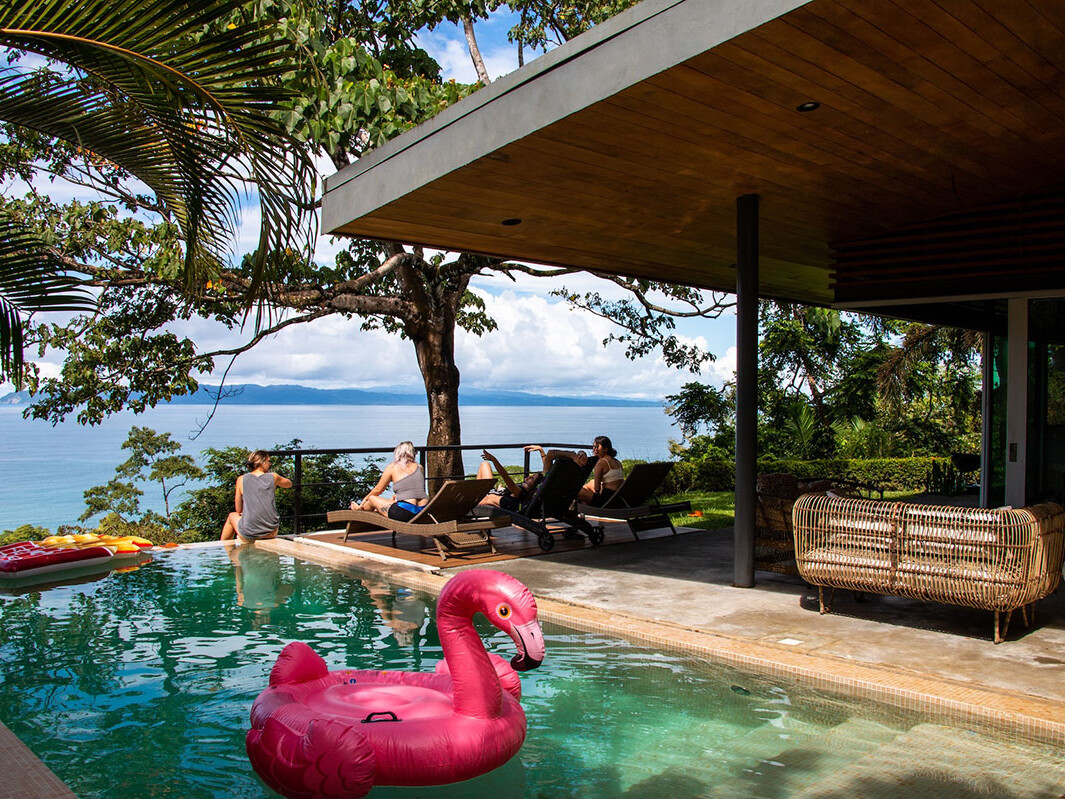 People relaxing at an infinity pool at Mokum Surf Club Costa Rica retreat
