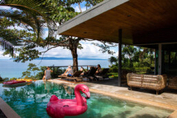 People relaxing at an infinity pool at Mokum Surf Club Costa Rica retreat