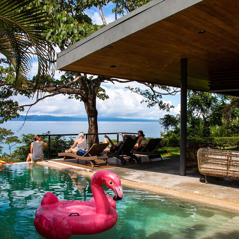 People relaxing at an infinity pool at Mokum Surf Club Costa Rica retreat