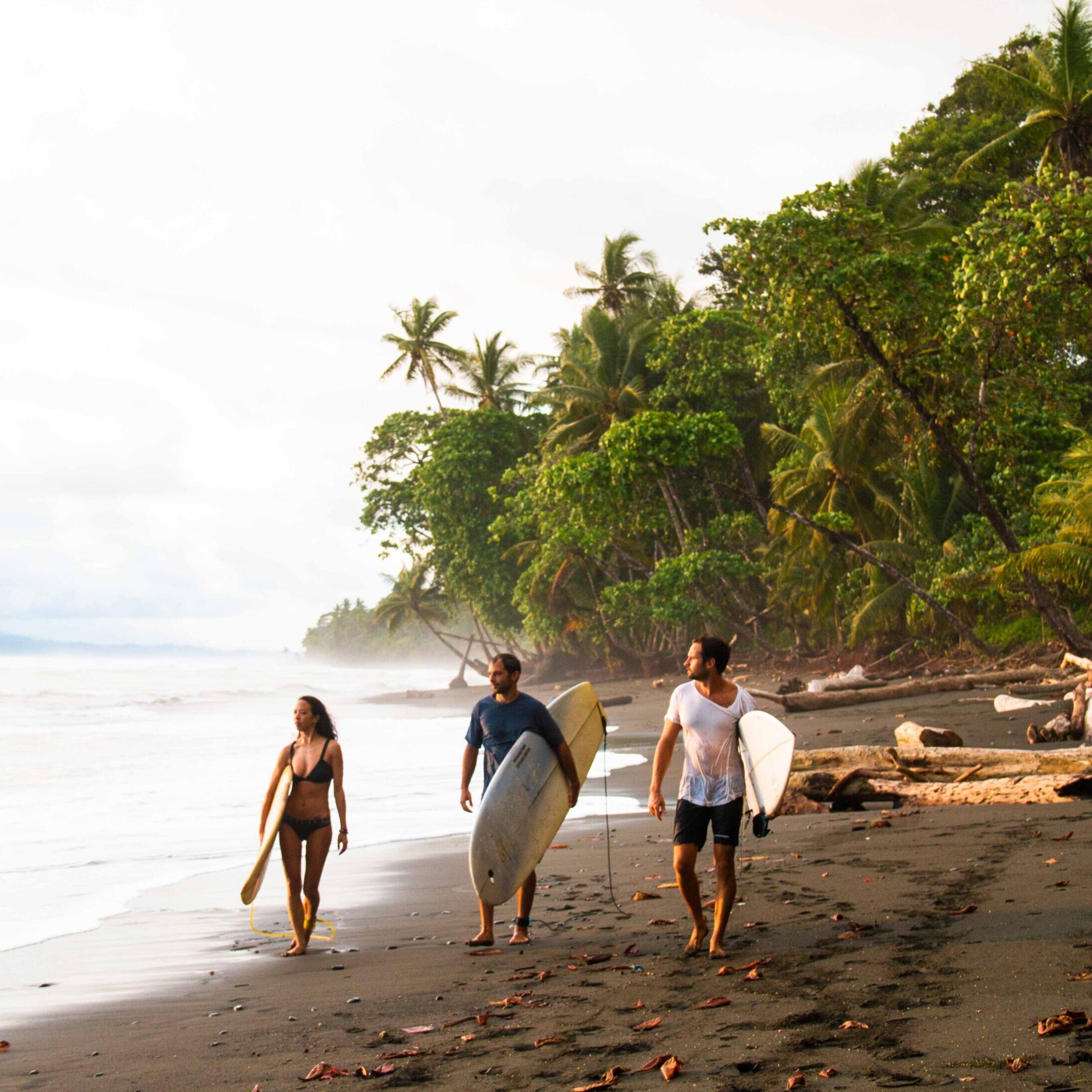 Surfers walking along the beach in Costa Rica during a Mokum Surf Club surf retreat