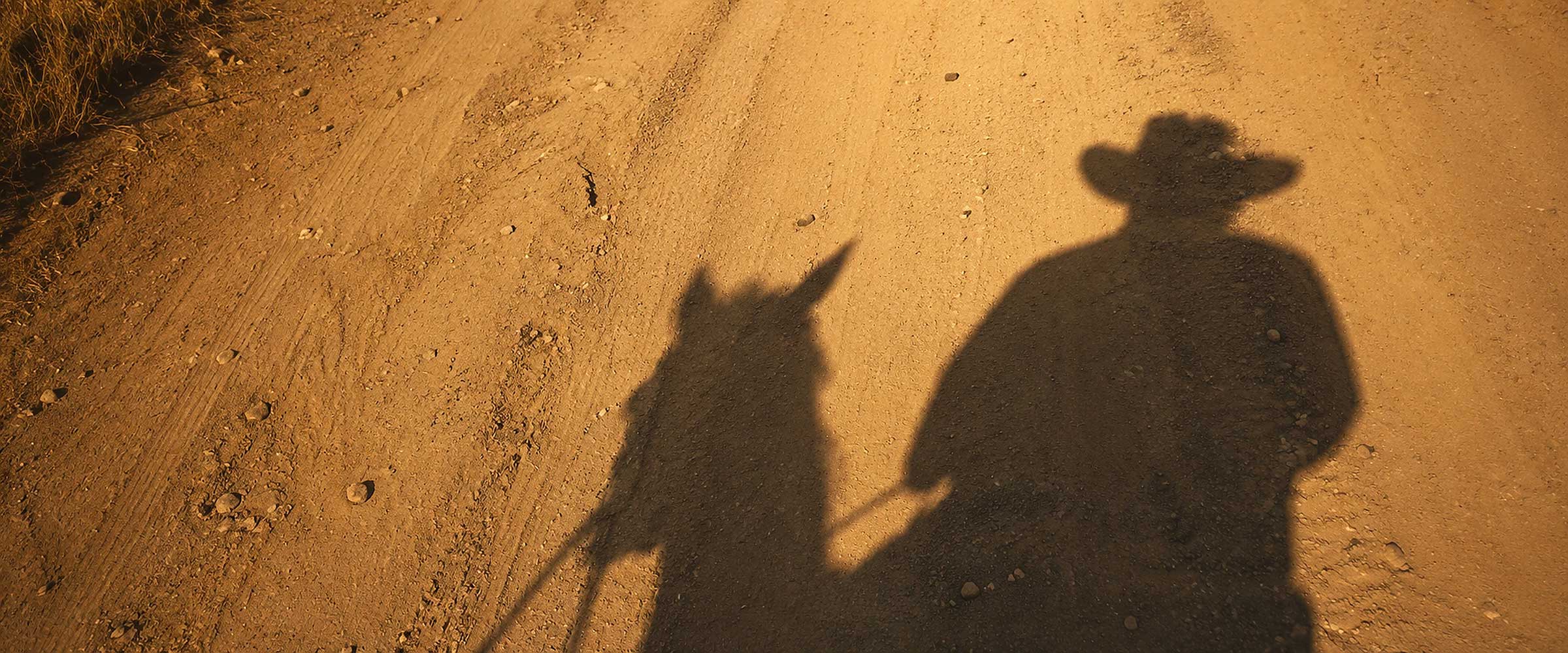 Shadow of a sabanero on horseback in the dry hills of Guanacaste, Costa Rica